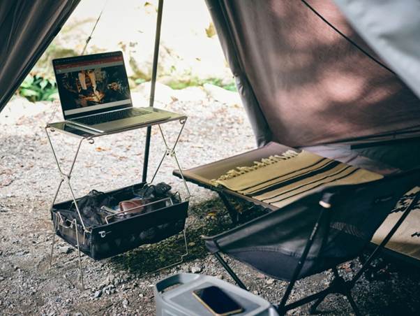 A computer on a table next to a table and a chair

AI-generated content may be incorrect.