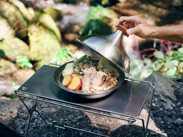 A person holding a metal lid over a pan of food

AI-generated content may be incorrect.