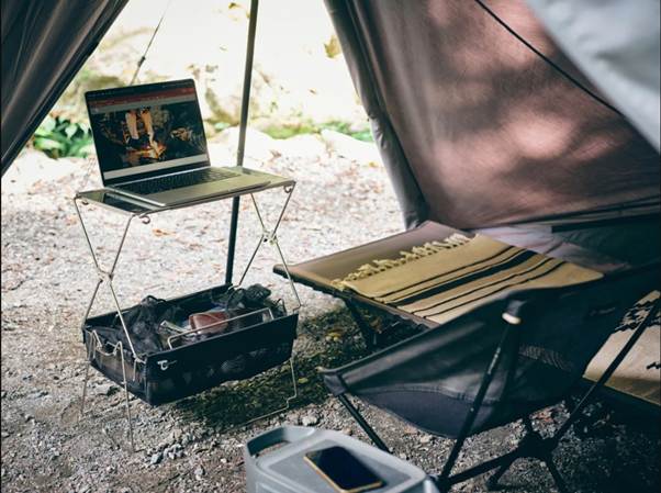 A computer on a table next to a table and a chair

AI-generated content may be incorrect.