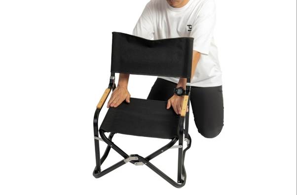 A person kneeling on a folding chair

AI-generated content may be incorrect.